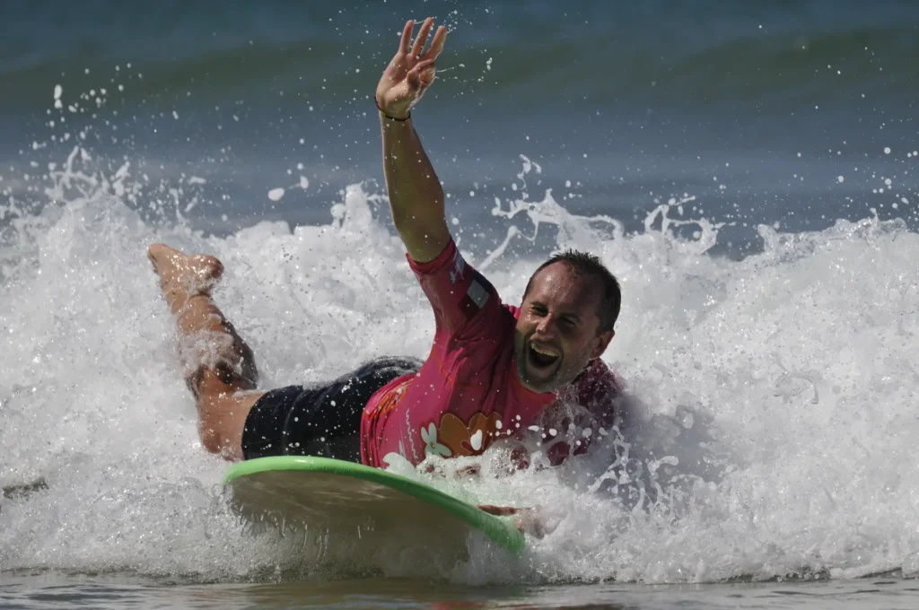 Adulte débutant surf mousse sur une vague Côte Sauvage – ESCS La Palmyre Côte Sauvage