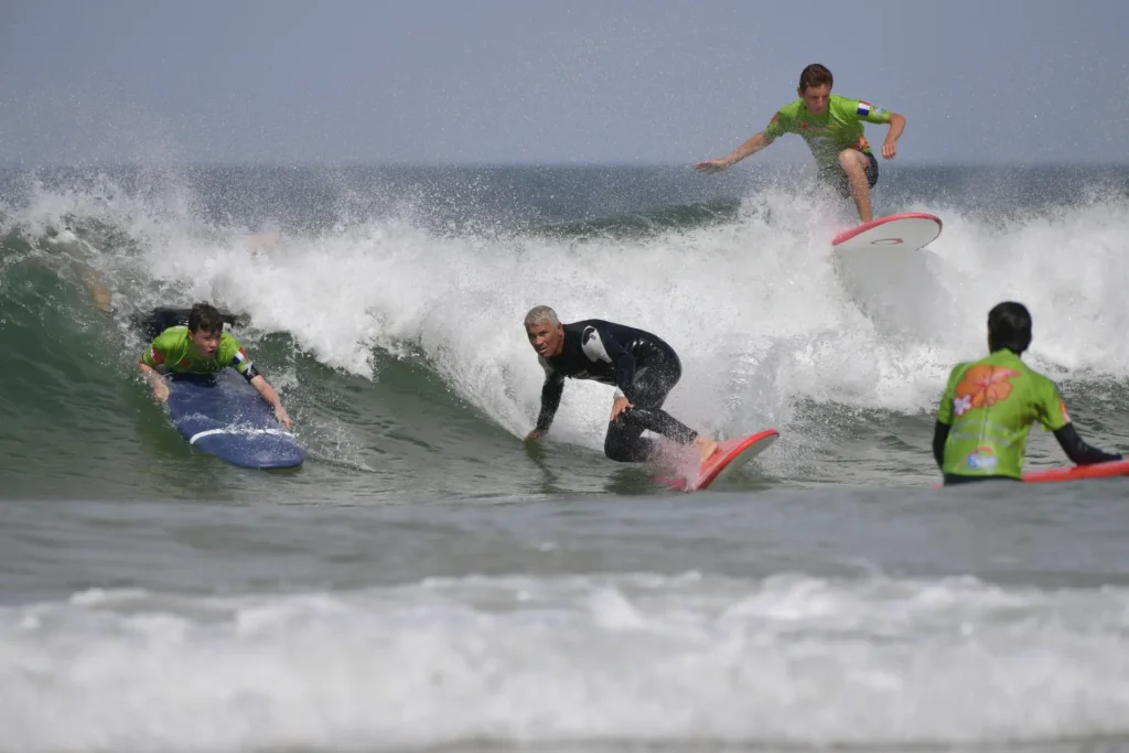 Cours de surf collectif surf Côte Sauvage groupe sur une vague moniteur de surf – ESCS La Palmyre Côte Sauvage