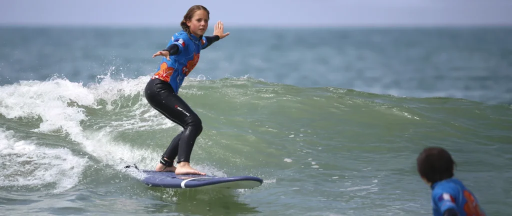 Cours de surf de surf enfant en glisse sur une vague Côte Sauvage La Palmyre – ESCS La Palmyre Côte Sauvage