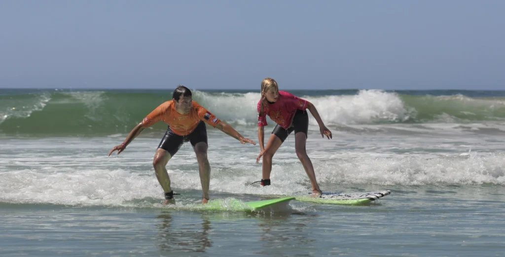 Cours de surf de surf enfant moniteur de surf sur une vague Côte Sauvage – ESCS La Palmyre Côte Sauvage