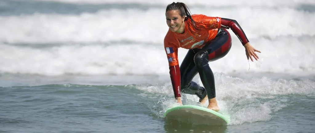 Élève debout sur la planche de surf sur une vague cours de surf de surf La Palmyre ESCS – ESCS La Palmyre Côte Sauvage