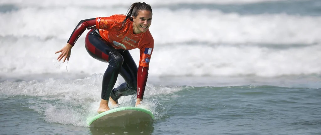 Élève surf debout sur la planche de surf sur une vague cours de surf Côte Sauvage ESCS – ESCS La Palmyre Côte Sauvage