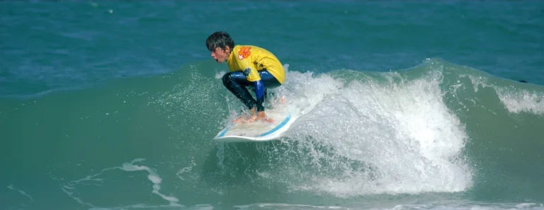 Élève surf lycra jaune sur une vague Côte Sauvage ESCS – ESCS La Palmyre Côte Sauvage
