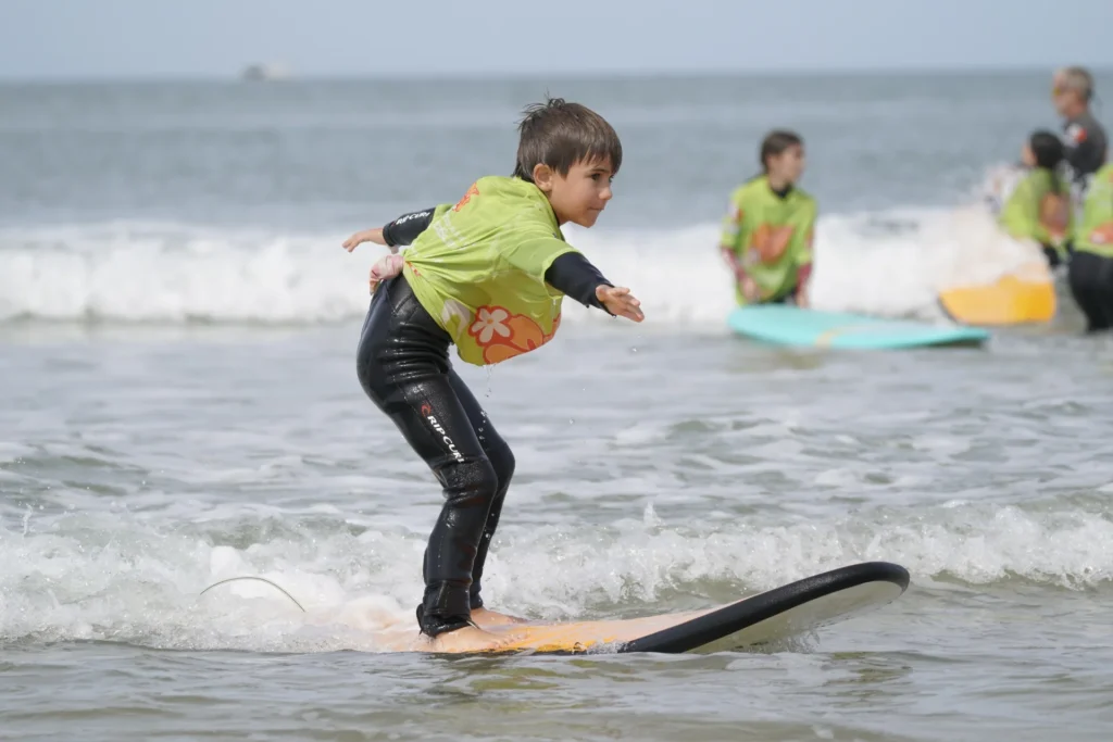 Enfant debout sur la planche de surf planche de surf cours de surf de surf Côte Sauvage ESCS – ESCS La Palmyre Côte Sauvage