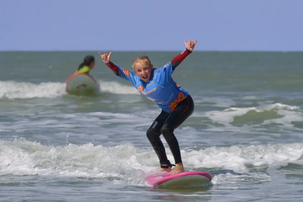 Enfant surf joie shaka sur une vague Côte Sauvage ESCS – ESCS La Palmyre Côte Sauvage
