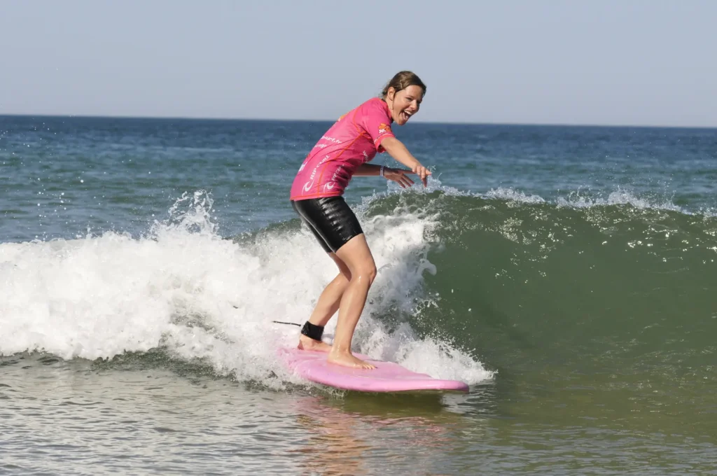 Femme adulte surf sur une vague Côte Sauvage sourire joie – ESCS La Palmyre Côte Sauvage