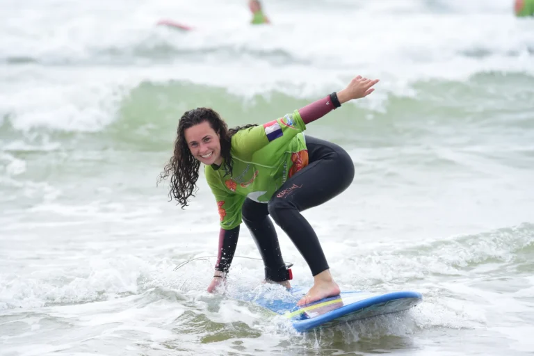 Femme souriante debout sur la planche de surf planche de surf cours de surf de surf Côte Sauvage – ESCS La Palmyre Côte Sauvage