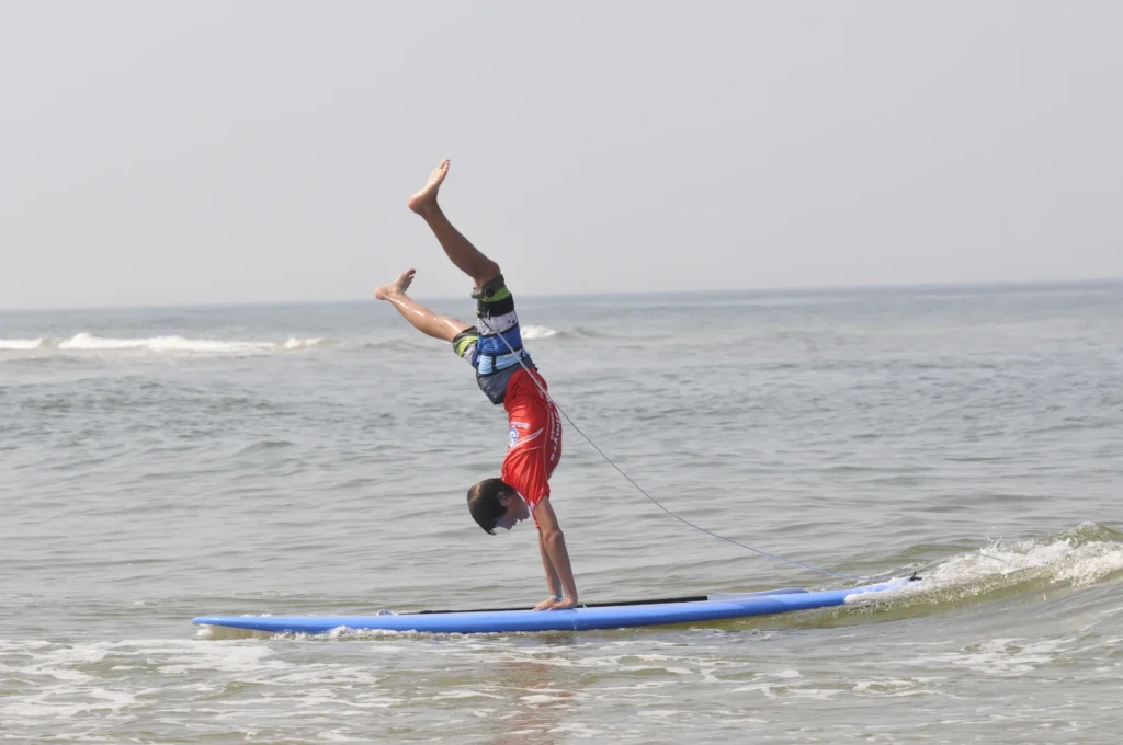 Jeune surfeur acrobatie equilibre planche de surf Côte Sauvage – ESCS La Palmyre Côte Sauvage