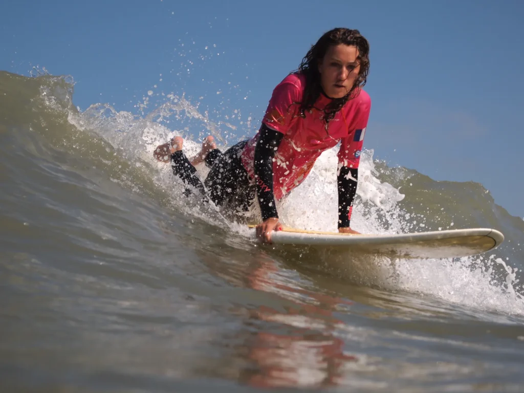 Surfeuse take off sur une vague Côte Sauvage cours de surf de surf – ESCS La Palmyre Côte Sauvage